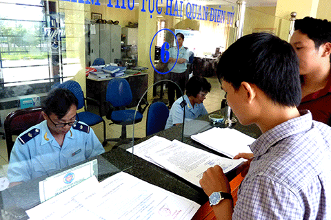 Cán bộ Hải quan Hà Nội hướng dẫn DN hoàn thiện tờ khai. Nguồn: PV.