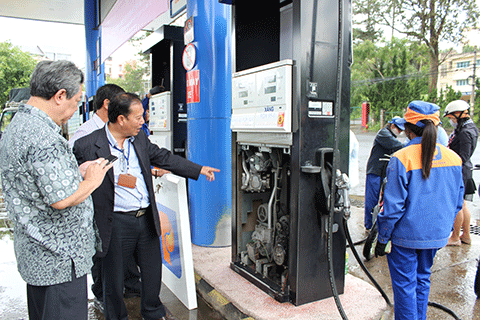 Kiểm tra việc dán tem đồng hồ tổng của cột bơm xăng tại Cửa hàng xăng dầu số 1 (Công ty TNHH dầu Lâm Đồng).