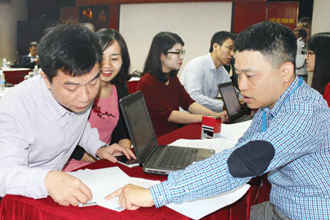 Cán bộ Cục Thuế TP. Hà Nội hướng dẫn người nộp thuế làm hồ sơ quyết toán thuế. Ảnh: NM