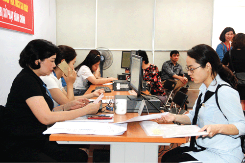 Cán bộ Cục Thuế Hà Nội tiếp nhận hồ sơ quyết toán thuế TNCN của người nộp thuế. Ảnh: NM