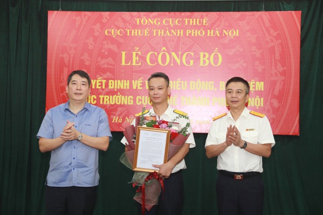 Thứ trưởng Bộ Tài chính Cao Anh Tuấn và Quyền Tổng cục trưởng Tổng cục Thuế Mai Xuân Thành trao Quyết định và tặng hoa cho tân Cục trưởng Cục Thuế Hà Nội.
