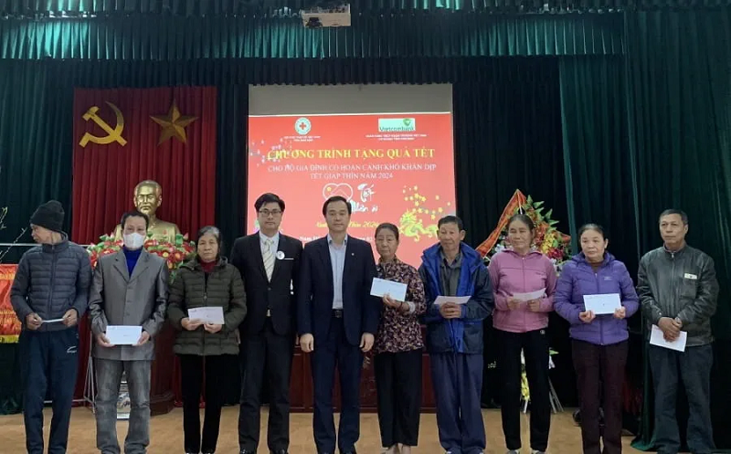 Ông Nguyễn Hữu Dụng - Phó Giám đốc Vietcombank Nam Định (thứ 5 từ trái sang) cùng đại diện Hội chữ thập đỏ tỉnh trao quà cho người có hoàn cảnh khó khăn tại huyện Nam Trực
