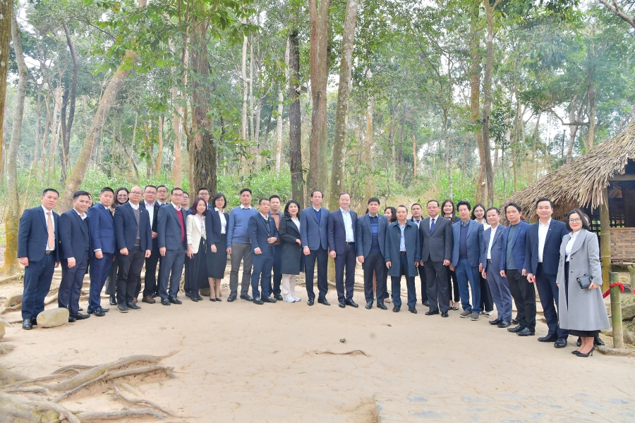 Các đại biểu chụp hình lưu niệm trước lán Nà Nưa, Khu di tích lịch sử quốc gia đặc biệt Tân Trào