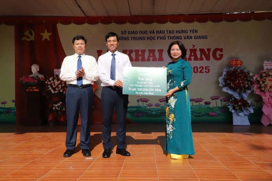 Ông Hoàng Ngọc Anh - Phó Giám đốc Vietcombank Hưng Yên, Chủ tịch công đoàn Chi nhánh (đứng giữa) và ông Trần Quốc Toản - Phó Bí thư thường trực tỉnh ủy Hưng Yên (bên trái) trao quà tặng cho trường THPT Văn Giang