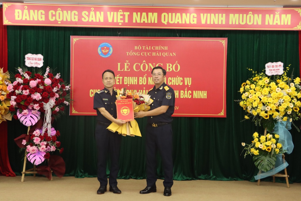 Phó Tổng cục trưởng Tổng cục Hải quan Trần Đức Hùng trao quyết định và tặng hoa chúc mừng tân Cục trưởng Cục Hải quan Bắc Ninh Phạm Chí Thành. 