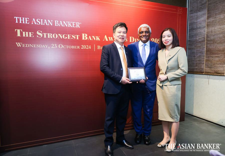 Đại diện Vietcombank, ông Phan Thanh Hải - Phó Giám đốc Trung tâm thanh toán (ngoài cùng bên trái) và bà Phạm Vân Giang - Phó Trưởng ban Định chế tài chính (ngoài cùng bên phải) nhận giải thưởng từ đại diện TAB