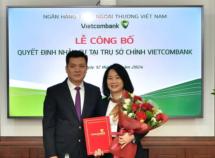 Ông Hồ Văn Tuấn - Phó Tổng Giám đốc trao quyết định và tặng hoa chúc mừng bà Lê Vân Trinh - tân Phó Giám đốc Trung tâm hỗ trợ khách hàng TSC Vietcombank