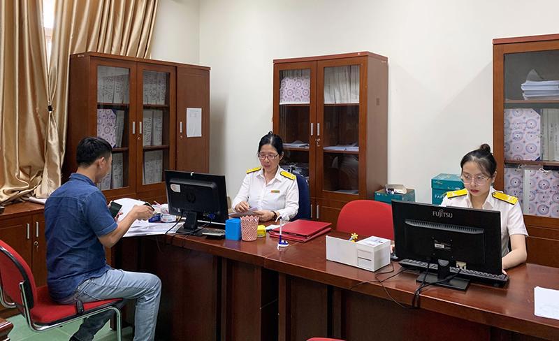 Cán bộ Cục Thuế Quảng Bình hỗ trợ người nộp thuế thực hiện các thủ tục kê khai thuế.