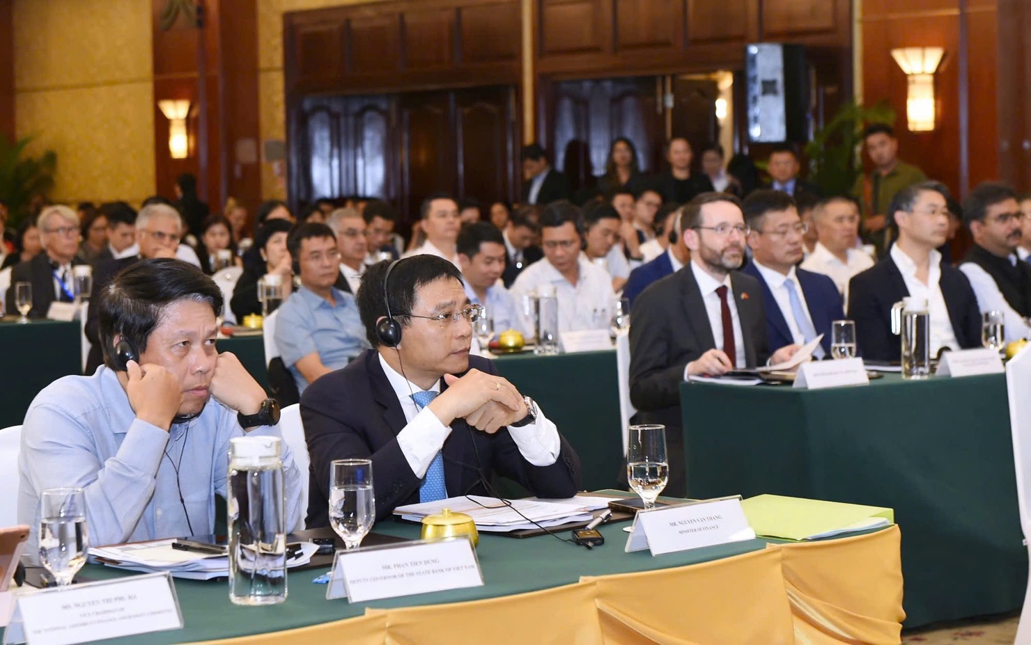 Bộ trưởng Bộ Tài chính Nguyễn Văn Thắng (bên phải) nghe thảo luận của các chuyên gia liên quan đến chủ đề "Xây dựng Trung tâm tài chính tại Việt Nam".