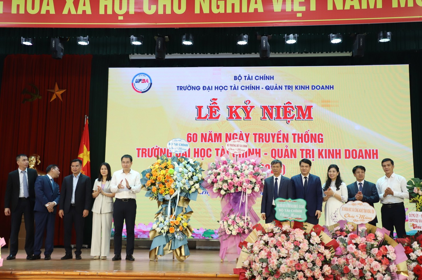Lãnh đạo Trường Đại học Tài chính - Quản trị kinh doanh đón nhận lẵng hoa chúc mừng của Bộ trưởng Nguyễn Văn Thắng.