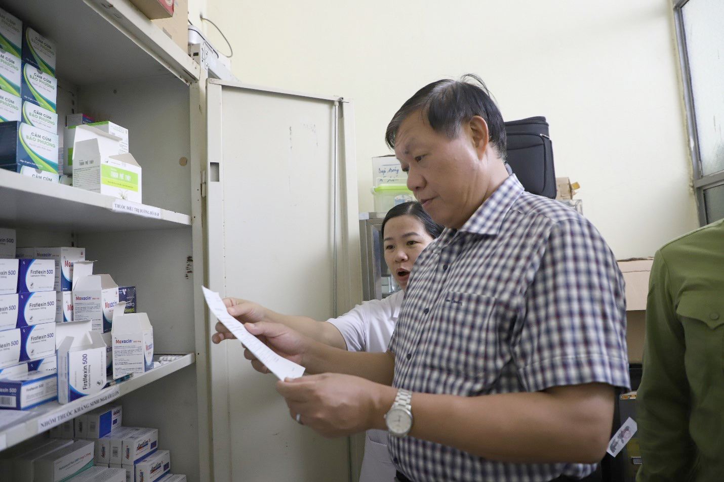 Thứ trưởng Đỗ Xuân Tuyên nghe Trưởng Trạm Y tế Sam Mứn giới thiệu các phòng, chức năng của trạm.