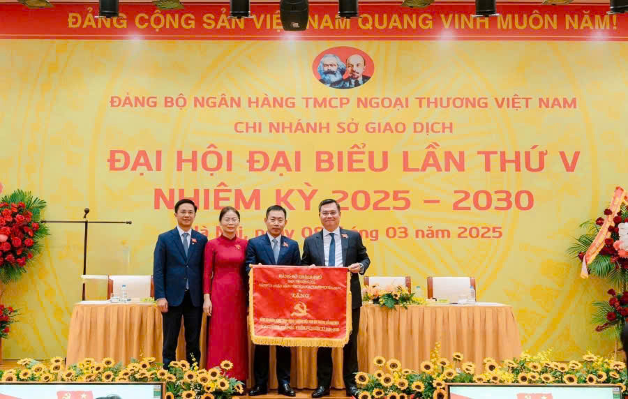 Đ/c Nguyễn Thanh Tùng - Ủy viên Ban Chấp hành Đảng bộ Chính phủ, Bí thư Đảng ủy, Chủ tịch HĐQT Vietcombank (ngoài cùng bên phải) trao tặng Cờ thi đua cho Đảng bộ Vietcombank Sở giao dịch đạt thành tích hoàn thành xuất sắc nhiệm vụ nhiệm kỳ 2020 - 2025.