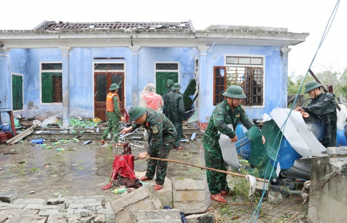 Lực lượng quân đội giúp dân dọn dẹp, khôi phục nhà cửa sau bão lũ.