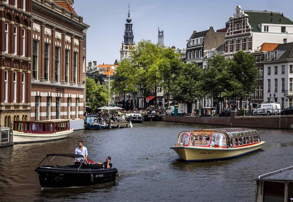 Hành khách đi du thuyền dọc theo một con kênh ở Amsterdam vào ngày 17/6/2022. Ảnh China Daily/Agencies