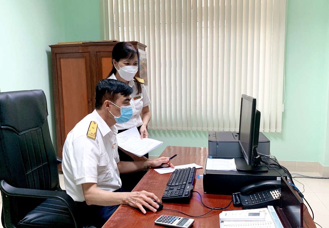C&aacute;n bộ Chi cục Thuế huyện Ea S&uacute;p kiểm tra hồ sơ xin gia hạn tiền thuế của người nộp thuế tr&ecirc;n hệ thống ng&agrave;nh. Ảnh: Thanh Hường