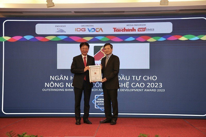 Ông Vũ Viết Ngoạn – Nguyên Chủ tịch Ủy ban giám sát Tài chính Quốc gia (phải) trao giải thưởng “Ngân hàng tiêu biểu vì cộng đồng” cho đại diện Agribank. Nguồn: Agribank