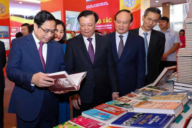 Thủ tướng v&agrave; c&aacute;c đại biểu thăm triển l&atilde;m s&aacute;ch, ảnh "H&agrave; Nội Ng&agrave;n hoa d&acirc;ng B&aacute;c" - Ảnh: VGP/Nhật Bắc