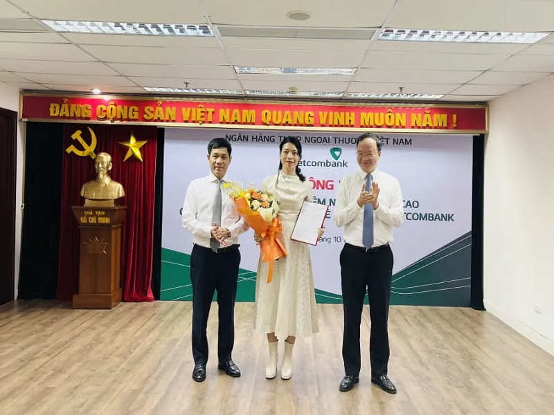 Phó Tổng Giám đốc Vietcombank Lê Quang Vinh (bên phải) trao quyết định và ông Nguyễn Trung Hà - Chủ tịch HĐTV VCBL (bên trái) tặng hoa chúc mừng bà Nguyễn Ngọc Trâm - tân Thành viên HĐTV VCBL 