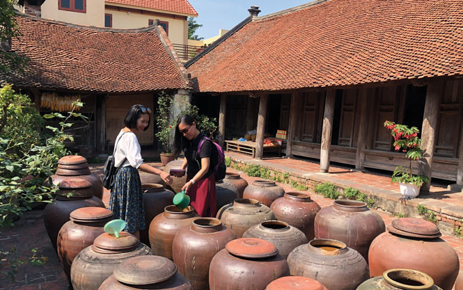 Du kh&aacute;ch tham quan t&igrave;m hiểu về c&aacute;c sản phẩm truyền thống tại l&agrave;ng cổ Đường L&acirc;m, thị x&atilde; Sơn T&acirc;y. Ảnh: VGP/TN