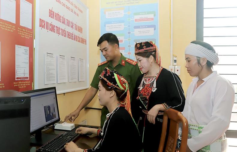 Người dân được cán bộ Công an hướng dẫn truy cập, trải nghiệm dịch vụ công trực tuyến.