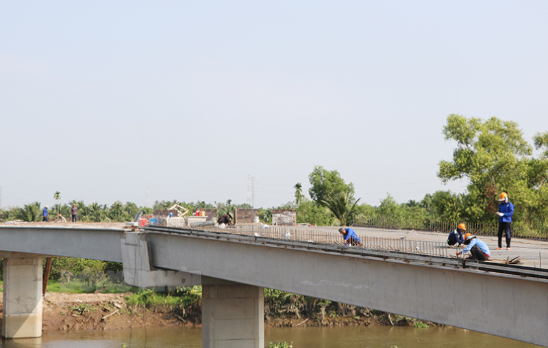 Thi công mặt cầu Ba Lai (trái). Ảnh: Thạch Thảo