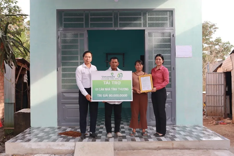  Ông Võ Tá Minh đại diện Vietcombank Đông Đồng Nai trao bảng tượng trưng nhà tình nghĩa cho 2 hộ gia đình đình bà Thị Hồng Ân và bà Thị Lang tại lễ trao tặng nhà tình thương  
