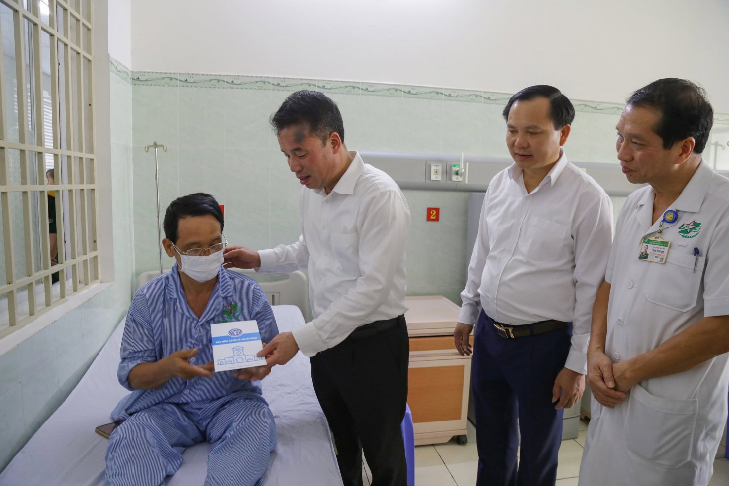 Tổng Giám đốc BHXH Việt Nam Nguyễn Thế Mạnh tặng sổ BHYT cho bệnh nhân nghèo đang điều trị tại Bệnh viên Quân y 105.