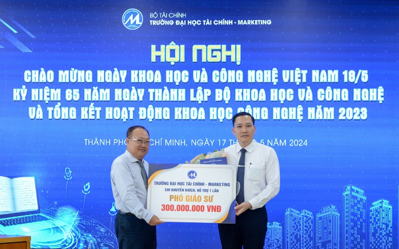 Phó Hiệu trưởng Phạm Quốc Việt trao quyết định tiếp nhận, tặng hoa chúc mừng PGS.TS. Ngô Sỹ Trung