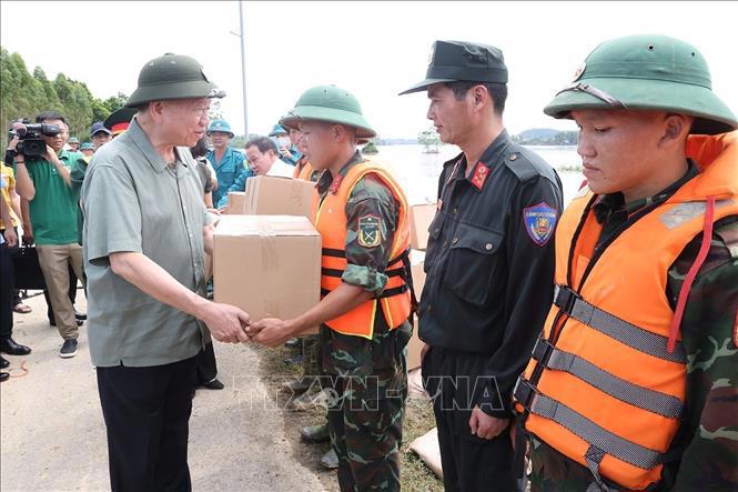 Tổng Bí thư, Chủ tịch nước tặng quà lực lượng làm nhiệm vụ củng cố, khắc phục sự cố một số điểm xung yếu ở đê sông Lô (xã Trường Sinh, huyện Sơn Dương) - Ảnh: TTXVN 
