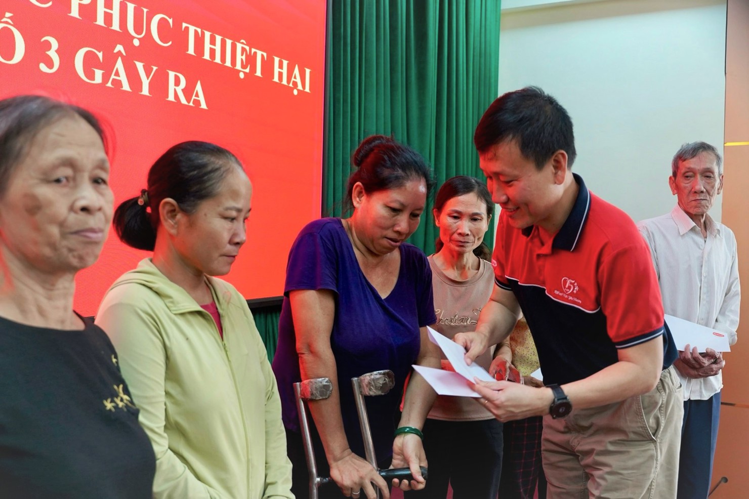 Đại diện một doanh nghiệp bảo hiểm trao quà, chia sẻ khó khăn cùng người dân bị ảnh hưởng bão số 3 (Yagi).