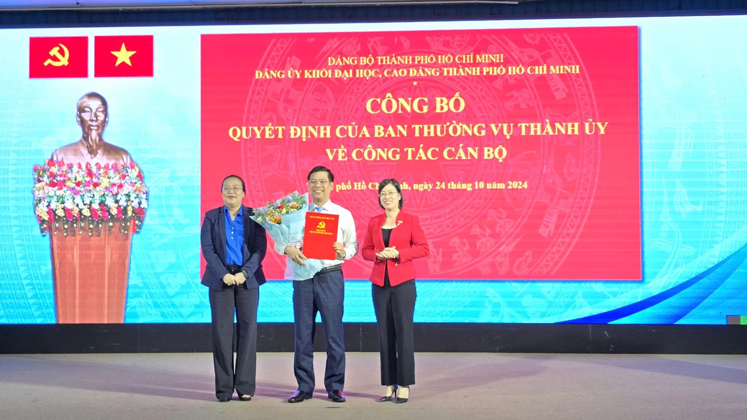 Đồng chí Nguyễn Thị Minh Hồng, Bí thư Đảng ủy Khối và đồng chí Nguyễn Thị Là, Phó Bí thư thường trực trao quyết định, tặng hoa chúc mừng đồng chí Phạm Tiến Đạt