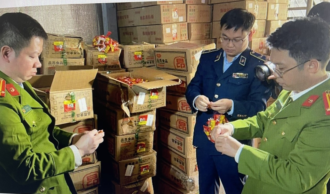 Các cán bộ chức năng đang kiểm tra và mở các gói thực phẩm tại hiện trường, nơi phát hiện hơn 13 tấn thực phẩm đóng gói sẵn có dấu hiệu nhập lậu.