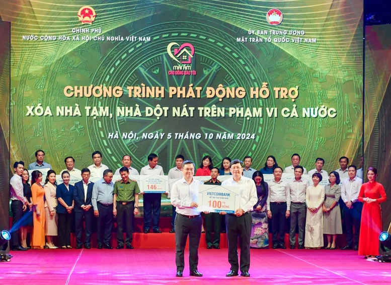Ông Nguyễn Thanh Tùng (bên trái) - Bí thư Đảng ủy, Chủ tịch HĐQT Vietcombank trao tượng trưng kinh phí 100 tỷ đồng hỗ trợ xoá nhà tạm, nhà dột nát ủng hộ cho địa phương.