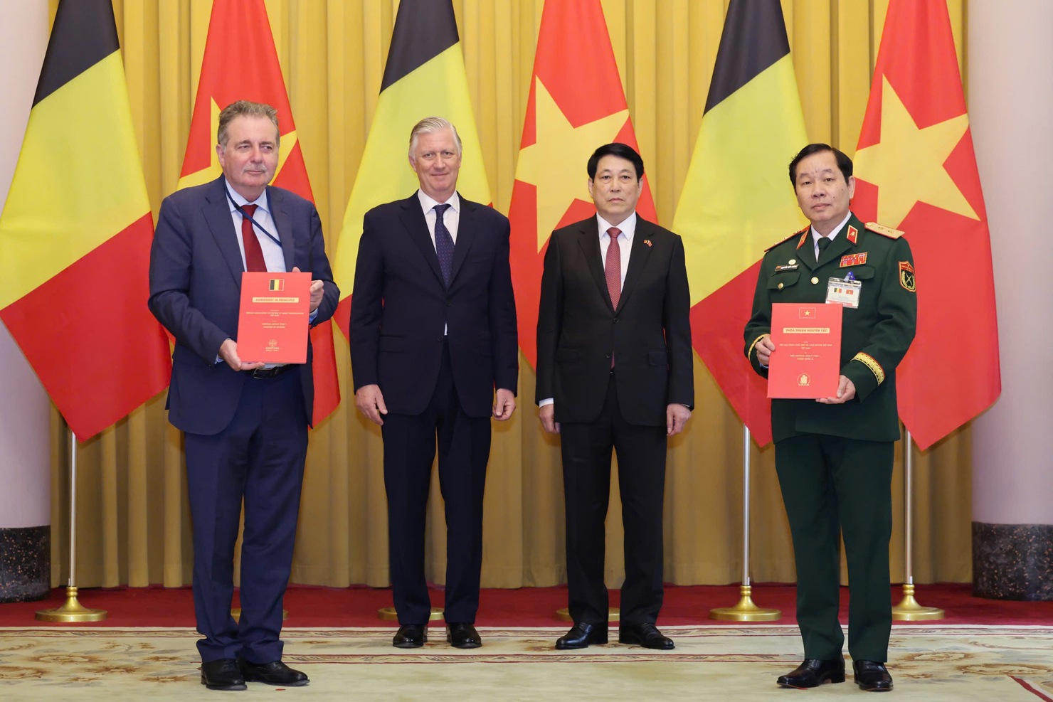 Chủ tịch nước Lương Cường v&agrave; Nh&agrave; vua Bỉ Philippe chứng kiến Trung tướng Nguyễn Hữu Ch&iacute;nh, Chủ tịch Hội Nạn nh&acirc;n chất độc da cam/dioxin Việt Nam v&agrave; Bộ trưởng, Thủ hiến V&ugrave;ng Thủ đ&ocirc; Brussels Rudi Vervoort trao đổi Thỏa thuận nguy&ecirc;n tắc giữa Hội nạn nh&acirc;n chất độc da cam/dioxin Việt Nam v&agrave; Quỹ Aquitara Impact Fund 1 của Bỉ - Ảnh: VGP/Nhật Bắc.