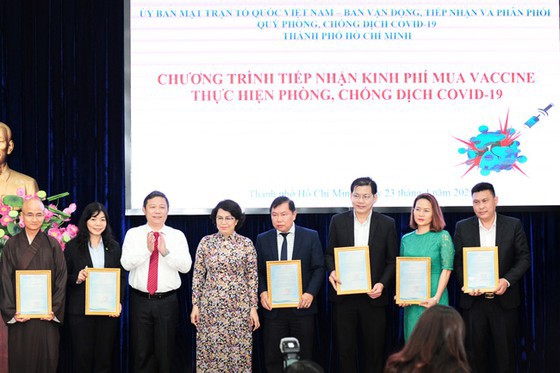 Ông Nguyễn Nam Hiền chụp hình lưu niệm cùng bà Tô Thị Bích Châu - Ủy viên Ban Thường vụ Thành ủy, Chủ tịch Ủy ban MTTQ Việt Nam TP. Hồ Chí Minh, ông Dương Anh Đức - Phó Chủ tịch UBND TP. Hồ Chí Minh và đại diện các doanh nghiệp, tổ chức, cá nhân đã ủng hộ kinh phí mua vaccine thực hiện công tác phòng, chống dịch Covid-19. Ảnh: Phạm Tú