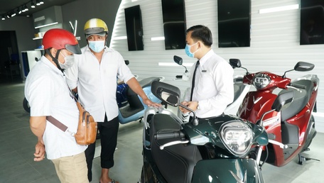 Tư vấn cách sử dụng cho khách hàng tại một cửa hàng bán xe điện tại TP. Vĩnh Long. Ảnh: Tấn Anh