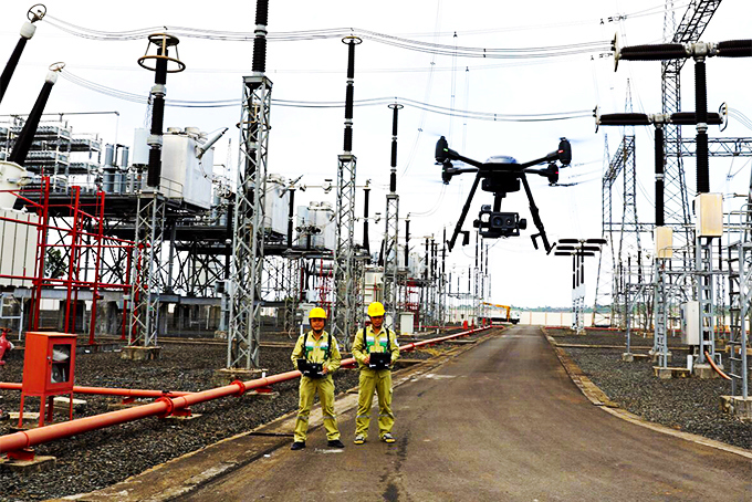 Đội ngũ kỹ thuật sử dụng flycam giám sát hệ thống lưới điện. Ảnh: Đình Lâm
