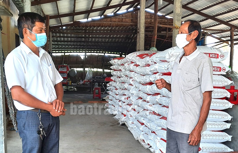 Nông dân Phạm Văn Biên (bên phải) trao đổi cùng Hội Nông dân xã Mỹ Chánh về khó khăn trong tiêu thụ nông sản. Ảnh: Anh Khoa