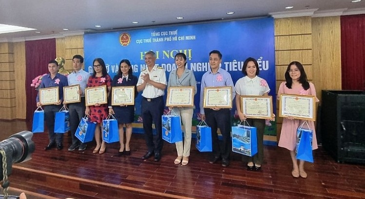 Ông Lê Duy Minh - Cục trưởng Cục Thuế TP. Hồ Chí Minh trao giấy khen cho các doanh nghiệp nộp thuế tiêu biểu năm 2021. Ảnh: M. Tân