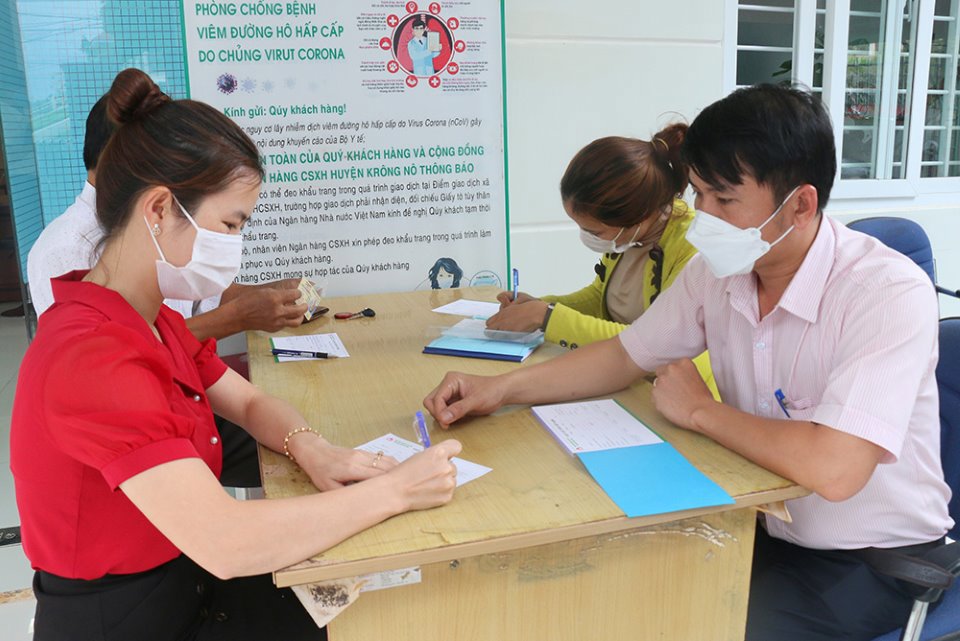 Cán bộ NHCSXH huyện Krông Nô hướng dẫn thủ tục cho người dân khi gửi tiết kiệm. Ảnh: Lương Nguyên