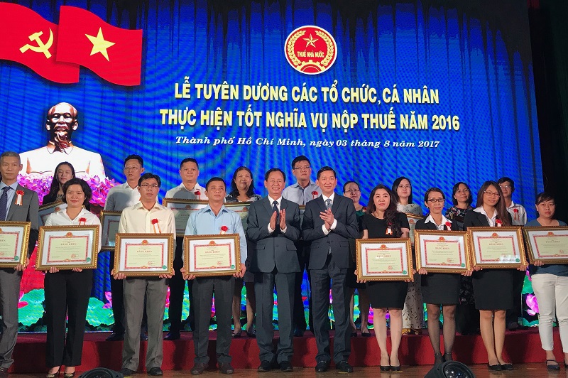 Ông Trần Vĩnh Tuyến, Phó Chủ tịch UBND TP. Hồ Chí Minh, ông Trần Ngọc Tâm, Cục trưởng Cục Thuế TP. Hồ Chí Minh trao giấy khen cho các DN, cá nhân nộp thuế tốt. Ảnh Đỗ Doãn