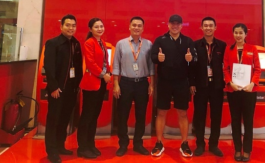 Ông Randy T (áo đen đứng giữa) vui mừng khi nhận lại túi xách và tiền bỏ quên trên máy bay của Jetstar Pacific. Ảnh Jetstar Pacific