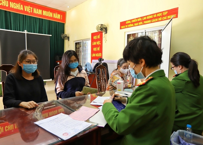 Lực lượng chức năng và người dân thực hiện nghiêm quy định về phòng, chống dịch khi làm thủ tục cấp CCCD gắn chip