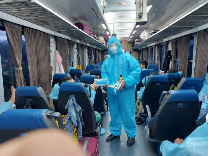 Từ tháng 10/2021, giá vé tối thiểu của một vé hành khách là 30.000 đồng/vé, áp dụng cho tất cả các loại chỗ, loại tàu. Ảnh: Tiếp viên toa xe phát khẩu trang cho hành khách trên chuyến tàu chuyên biệt đưa người dân từ TP. Hồ Chí Minh về quê