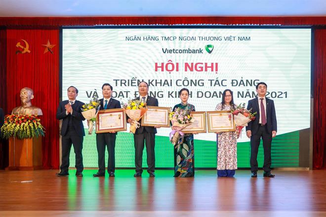 Chủ tịch HĐQT Nghiêm Xuân Thành (ngoài cùng, bên phải) và Phó Thống đốc NHNN Việt Nam Đoàn Thái Sơn (ngoài cùng, bên trái) trao Huân chương Độc lập và Huân chương Lao động hạng Nhì–Ba cho các tập thể và cá nhân của Vietcombank