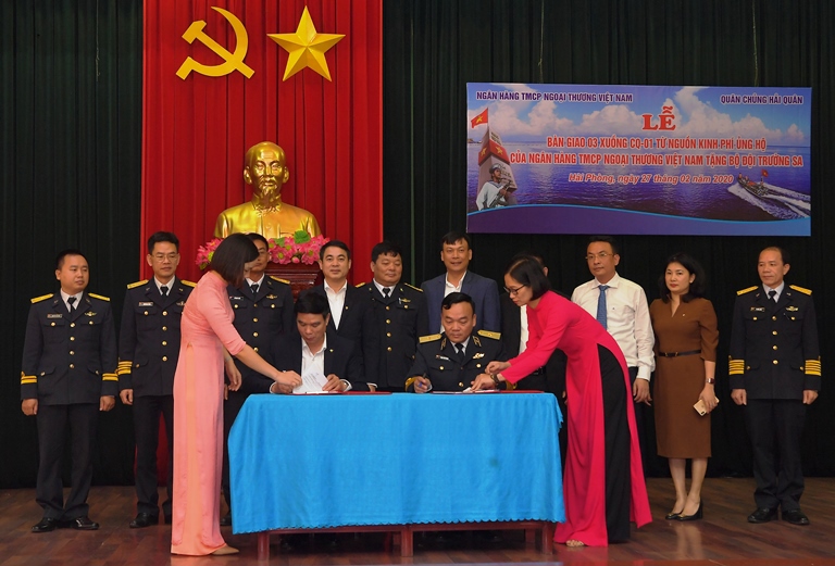 Ông Vũ Tiến Duật – Phó Bí thư thường trực Đảng ủy (ngồi bên trái) và Chuẩn đô đốc Phạm Văn Quang – Phó Chủ nhiệm Chính trị Hải quân (ngồi bên phải) ký biên bản bàn giao 3 xuồng CQ-01
