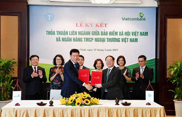 Đại diện BHXH Việt Nam, ông Nguyễn Đình Khương – Phó Tổng Giám đốc (hàng đầu, bên phải) cùng đại diện Vietcombank, ông Phạm Mạnh Thắng – Phó Tổng Giám đốc ký kết thoả thuận liên ngành
