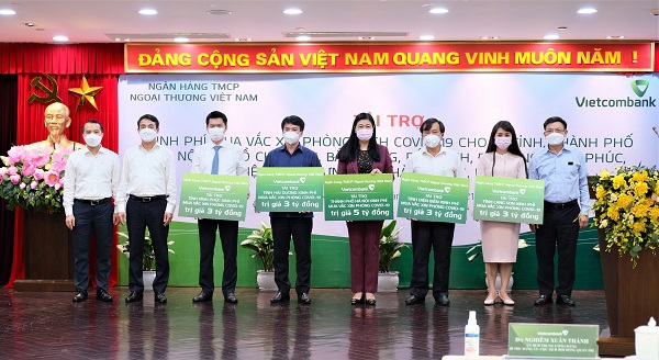 Đại diện Ban l&atilde;nh đạo Vietcombank &ocirc;ng Nghi&ecirc;m Xu&acirc;n Th&agrave;nh - Chủ tịch HĐQT (thứ 2 từ tr&aacute;i sang) trao kinh ph&iacute; t&agrave;i trợ mua vắc xin ph&ograve;ng Cocid-19 cho: H&agrave; Nội, Vĩnh Ph&uacute;c, Hải Dương, Điện Bi&ecirc;n, Lạng Sơn tại điểm cầu Trụ sở ch&iacute;nh Vietcombank tại H&agrave; Nội