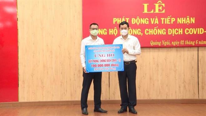 Đại diện Vietcombank Quảng Ngãi, ông Bùi Thanh Hà–Trưởng phòng Khách hàng doanh nghiệp (bên trái) trao biểu trưng ủng hộ Quỹ phòng chống dịch Covid -19 số tiền 100 triệu đồng