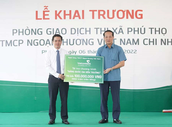 Ông Văn Tiến Thành - Giám đốc vietcombank Phú Thọ (bên trái) trao biểu trưng tài trợ 100 triệu đồng chương trình “Nâng bước em đến trường” cho đại diện lãnh đạo chính quyền địa phương